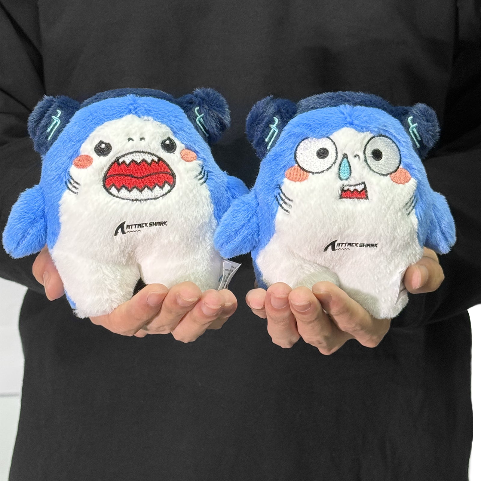 Attack Shark mascot plush toys held in hands
